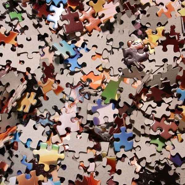 Puzzle dílky rozložené na stole v klidném domácím prostoru